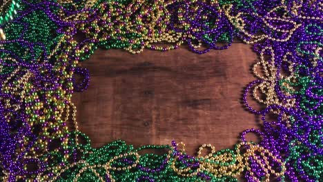 curtain of mardi gras beads parting to reveal colorful bead border with copy space