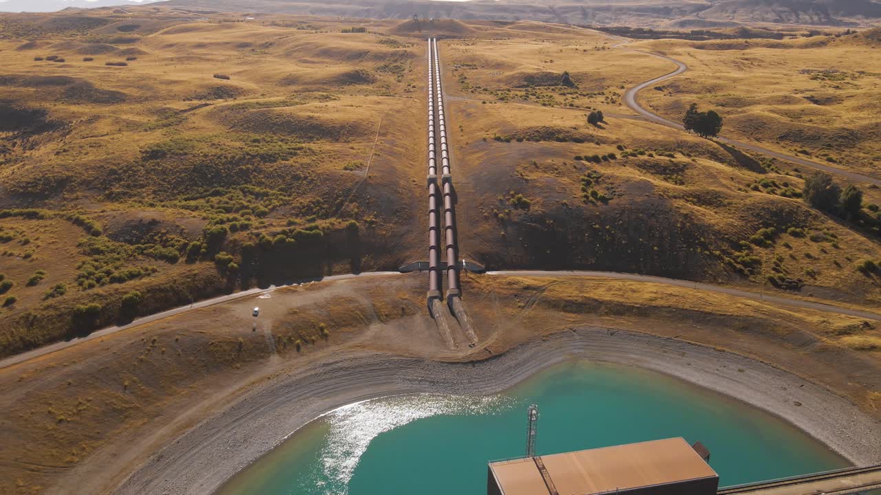 largas tuberías que dirigen el flujo de agua a la central hidroeléctrica en la orilla del lago