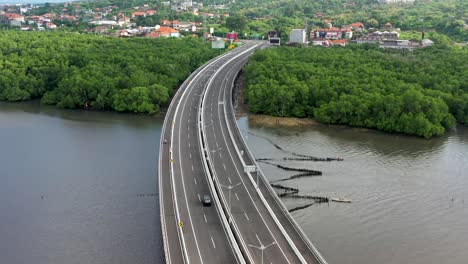 South-exit-of-Mandara-Toll-Road-in-Bali-Indonesia-with-cars-riding,-Aerial-flyover-shot