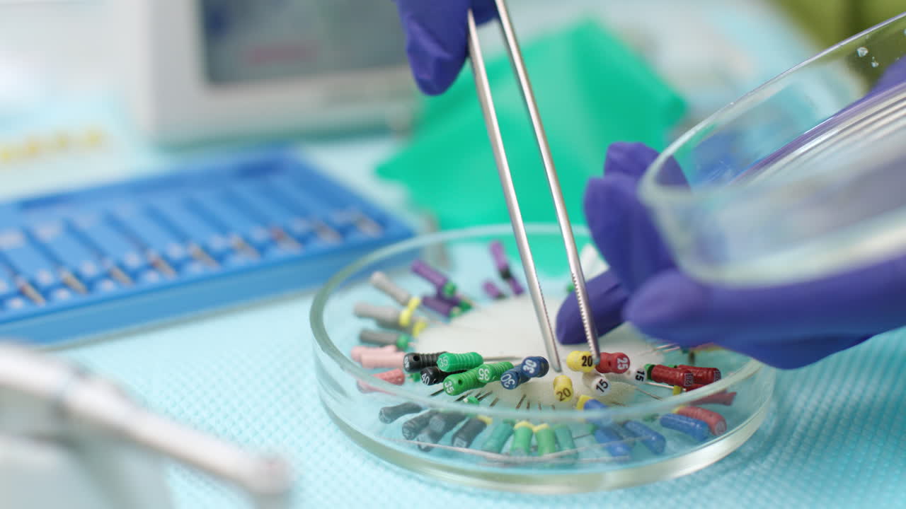 instrumentos endodónticos en una placa de petri de vidrio. el dentista selecciona a mano el archivo endodóntico