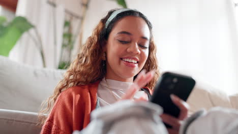 happy woman using phone on couch