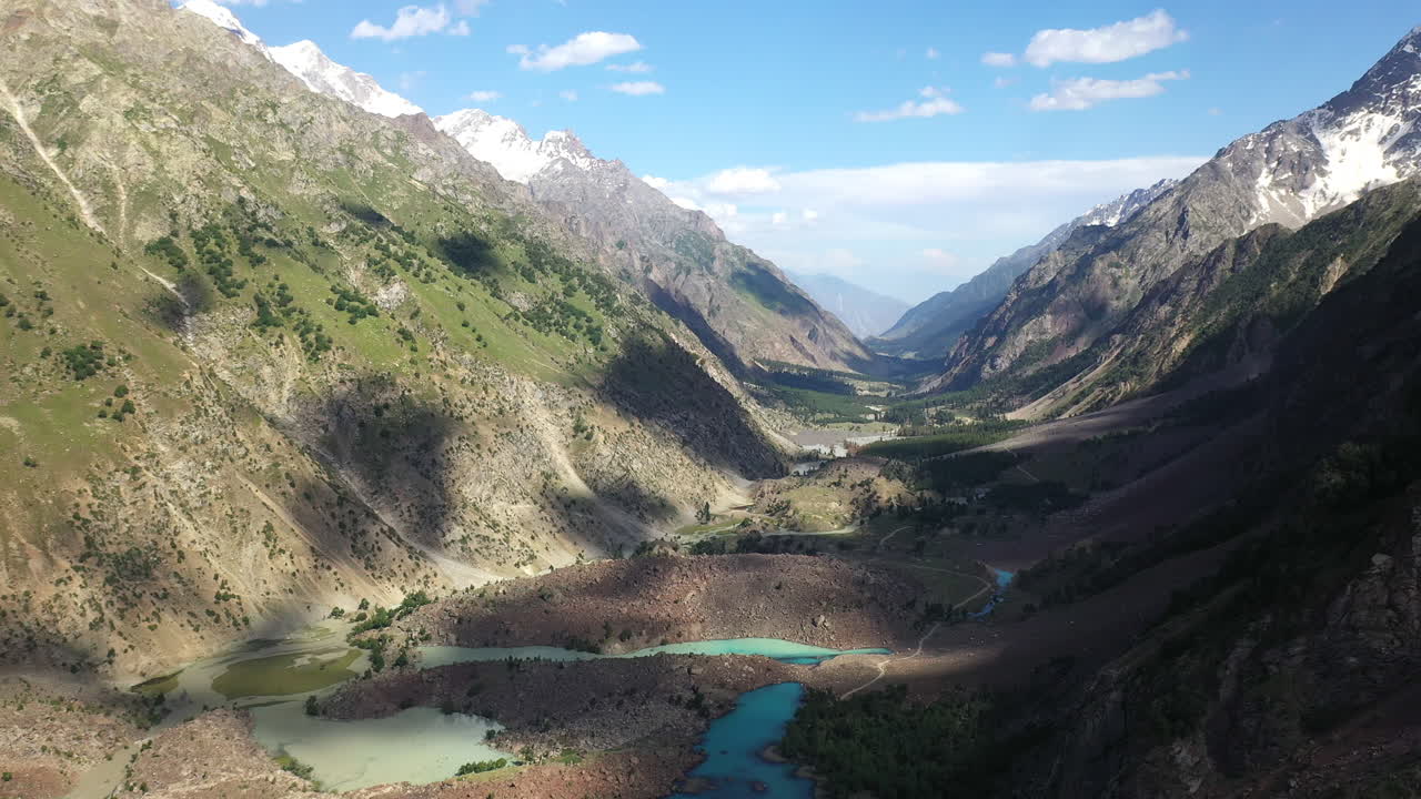 Cinematic drone shot of the mountains and valley at Naltar Valley in Pakistan, slowly rotating aerial shot