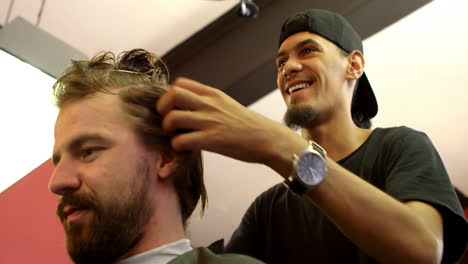 man interacting with barber while trimming his hair 4k