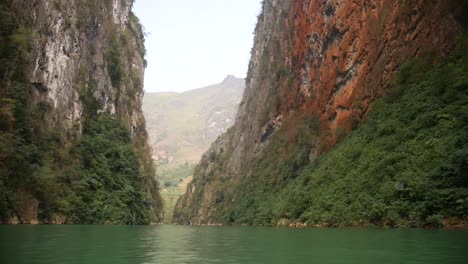 pov shot boat sailing in-between mountain cliff canyon in north vietnamese river