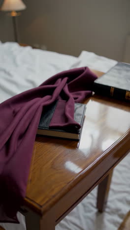 bible and maroon scarf on nightstand