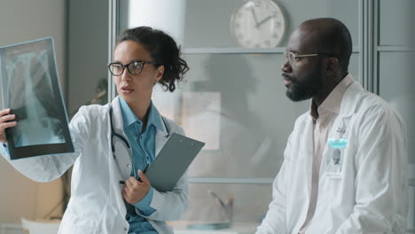 diverse doctors discussing chest x-ray during workday in clinic