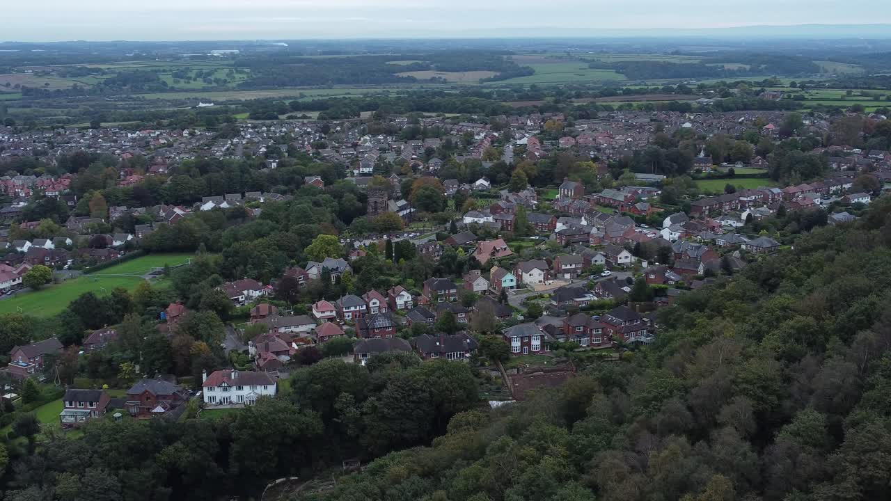 Aerial view above Halton North England coastal countryside town estate green space orbit right