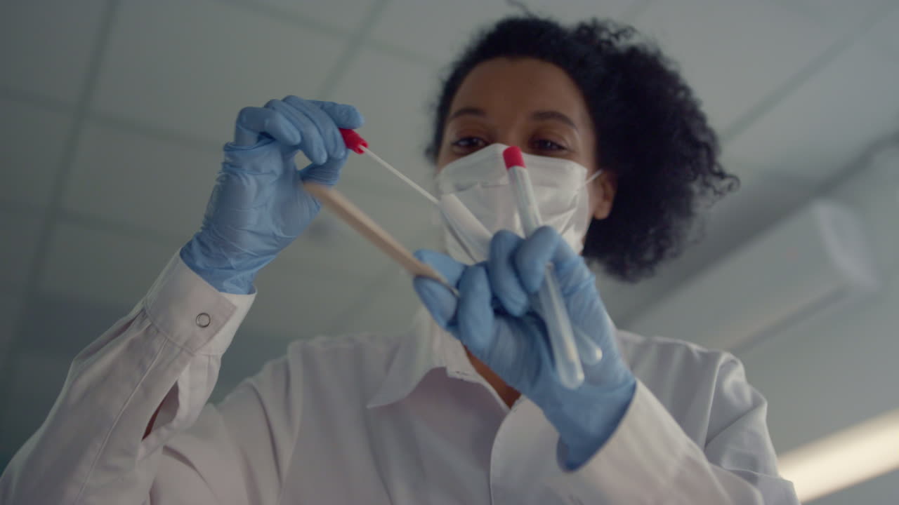 Woman doctor taking sample for corona test close up. Physician holding tube.