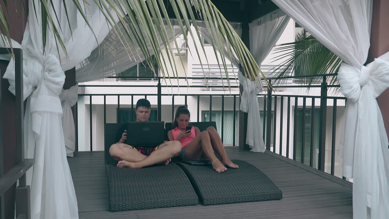 молодой парень работает на ноутбуке, а молодая леди серфирует в интернете.