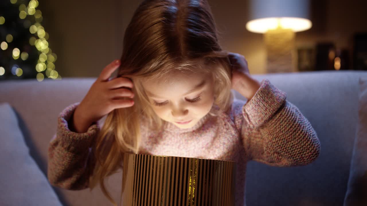 близкий портрет веселой кавказской девочки, открывающей коробку с рождественскими подарками с удивленным счастливым лицом. красивая женщина получает рождественский подарок с взволнованным лицом. дух нового года. праздничное празднование