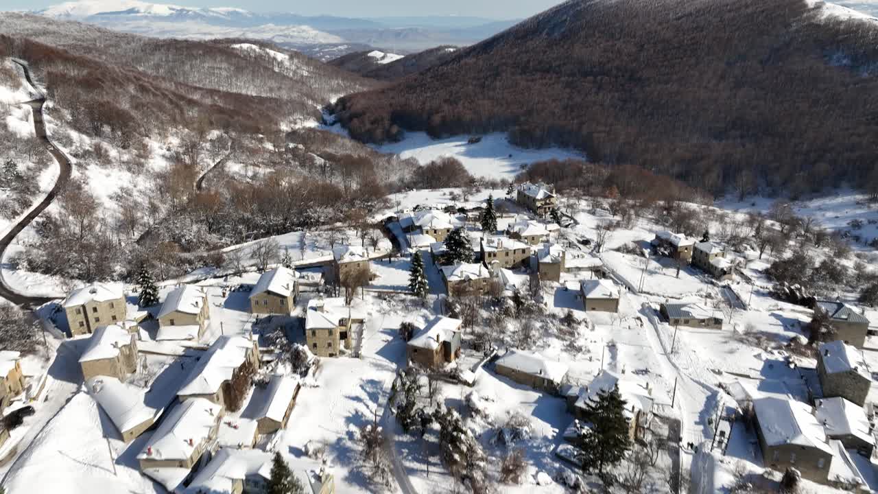 Aerial fly above snowed houses, village in Mediterranean mountain landscape of Nymfaio, Florina, Greece
