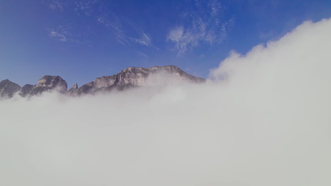 Flying between clouds in reverse and the orbital view of a mountain