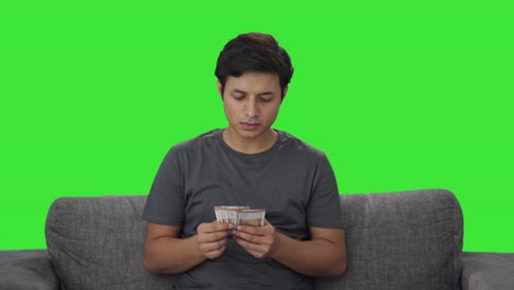 Sad-Indian-man-counting-money-Green-screen