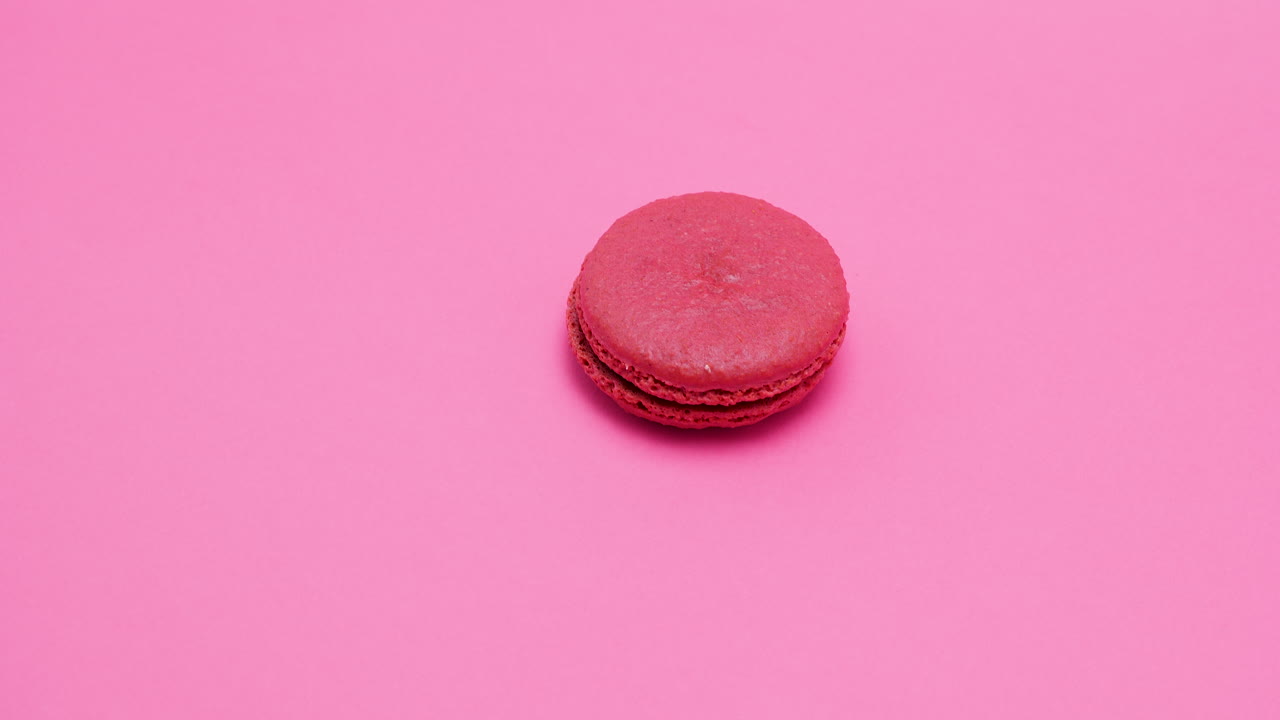 A delicious red macaron on a pink background