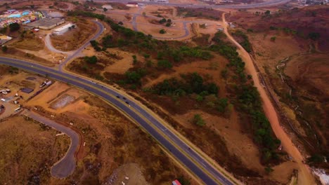 aerial high angle overview of highway road above lush forested mountains in asokoro, abuja, urban planning and road infrastructure in africa