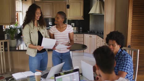 Group-of-happy-diverse-male-and-female-friends-working-together-in-kitchen-and-laughing