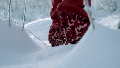 Primer-Plano-De-Piernas-Femeninas-Vestidas-Con-Ropa-Roja-De-Invierno-Caminando-Afuera-En-Una-Espesa-Nieve-Fresca-En-Un-Día-Soleado