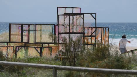 people interacting with abstract art on the beach