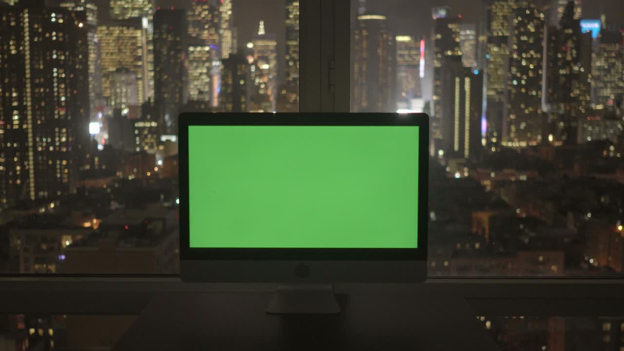 computer con schermo verde in un moderno edificio per uffici con lo sfondo del paesaggio cittadino.