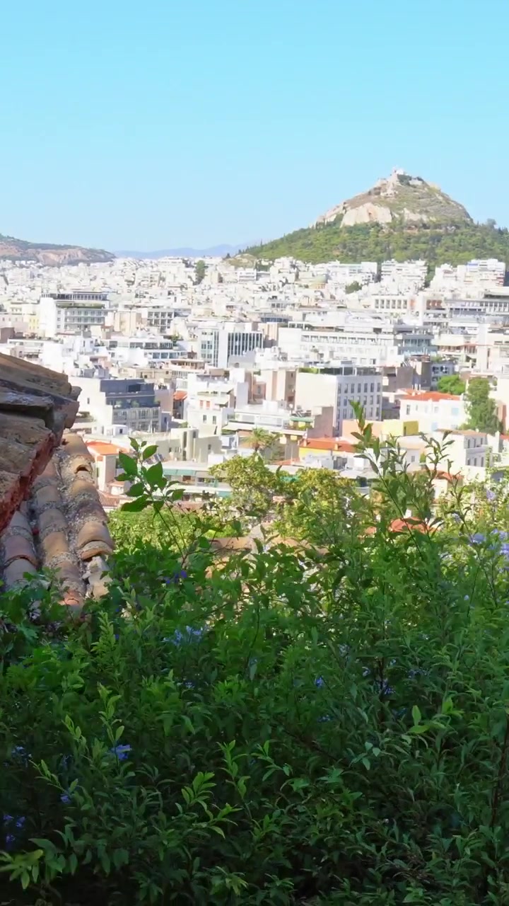 Tegole in terracotta che si affacciano sul panorama urbano di Atene