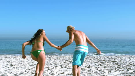 Handsome-man-running-with-his-friend-toward-the-sea