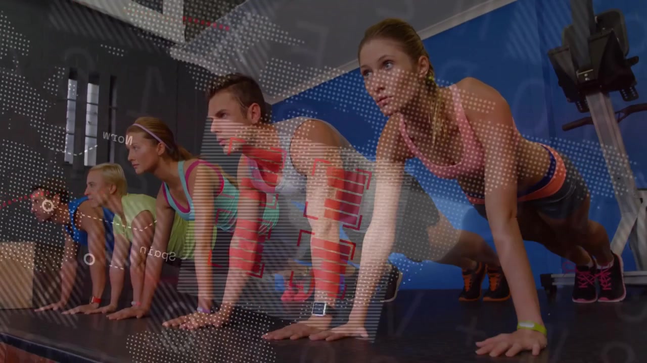 Antrenörün talimatıyla minderler üzerinde şınav çeken, dijital grafiklerle formu takip edilen fitness katılımcıları.