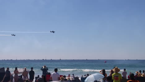 planes perform stunts over crowded beach and ocean