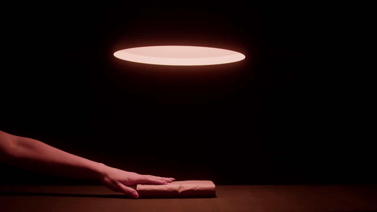 Mano colocando y tomando un pergamino misterioso bajo la luz de un foco.