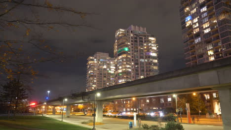 Canada-Line---SkyTrain-Running-On-Elevated-Guideways-With-Traffic-On-Road-At-Night-In-Downton-Vancouver,-BC,-Canada