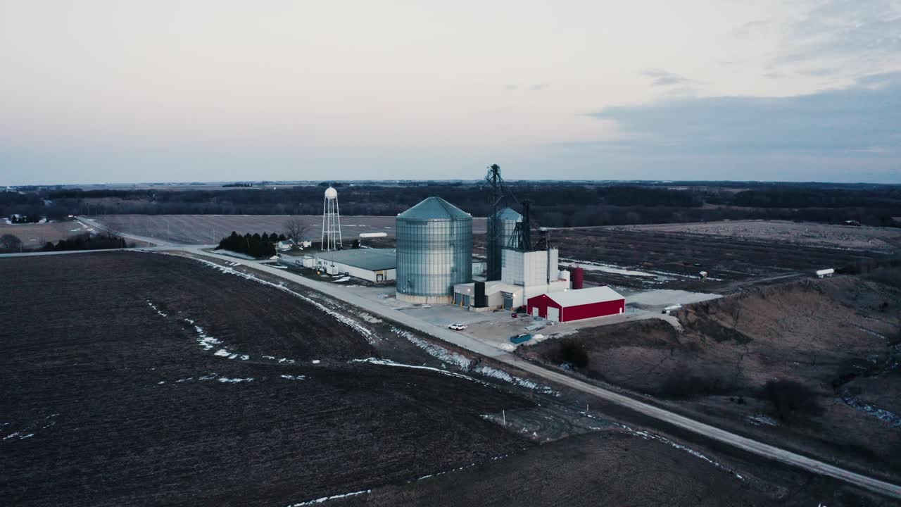 Drone shot approaching a farm's large grain silo at the end of the season