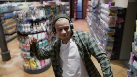 Mixed-race-guy-with-headphones-listening-to-the-music-and-funny-dance-wearing-plaid-shirt