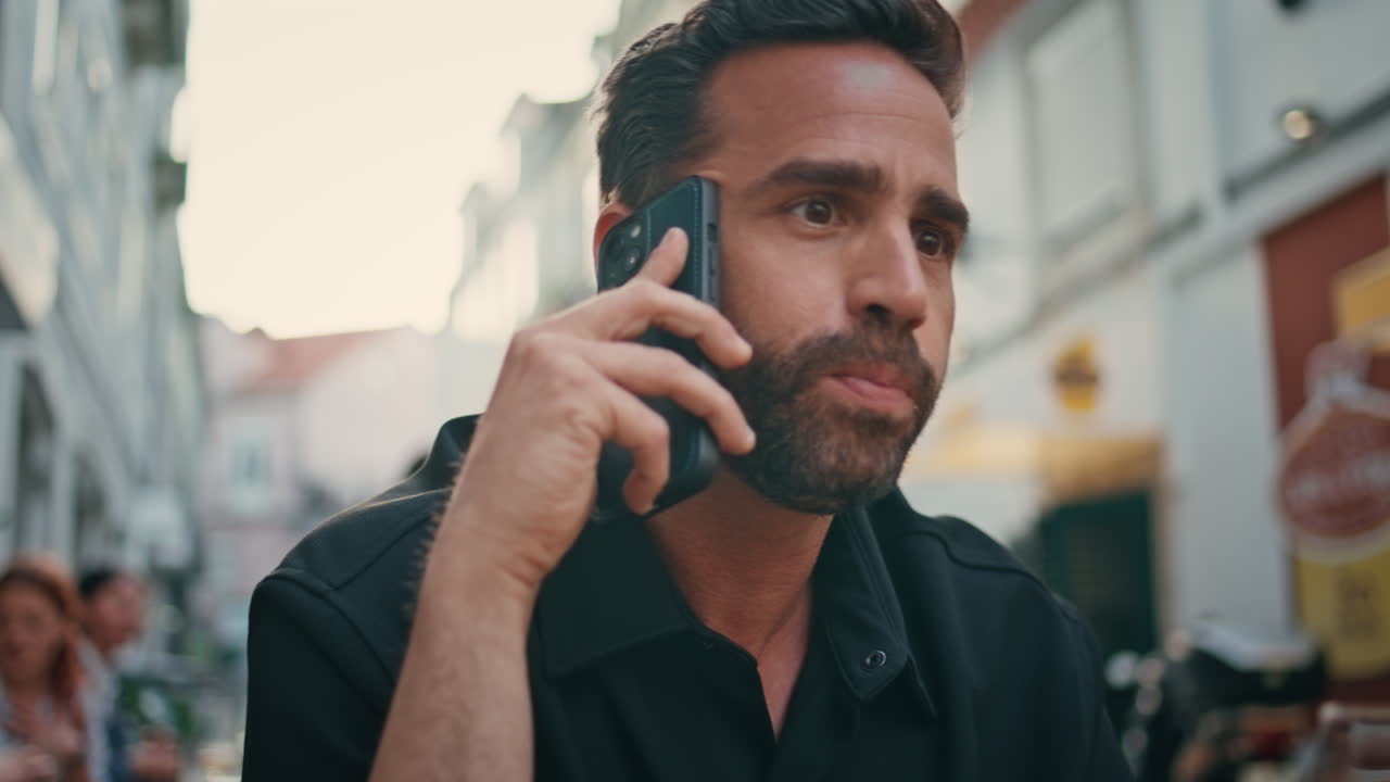 Bearded guy drinking wineglass calling at street cafe closeup. Man talking phone