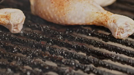 close up of bbq chicken thighs being placed on a hot grill