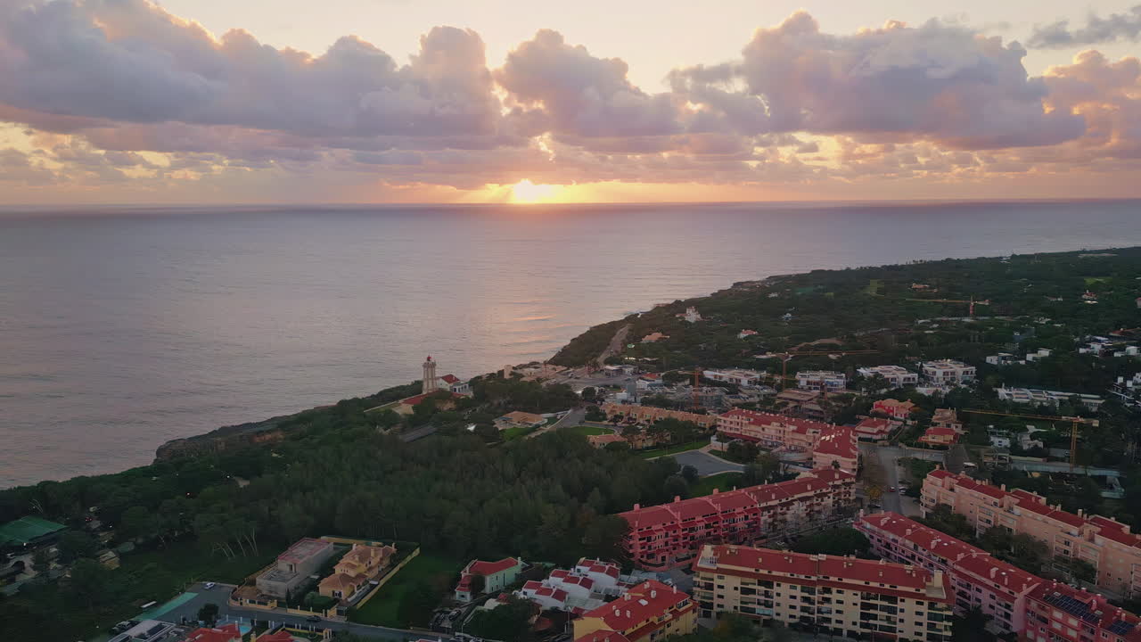 Cidade costeira situada em uma orla cênica com um pôr do sol dourado incrível ao fundo.