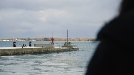 an "over the shoulder" shot of a boat dock with beach waves in slow motion during a cloudy day