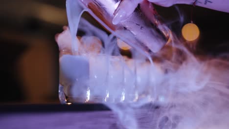dry ice smoking shot glasses filling up with cocktail (super slow motion)