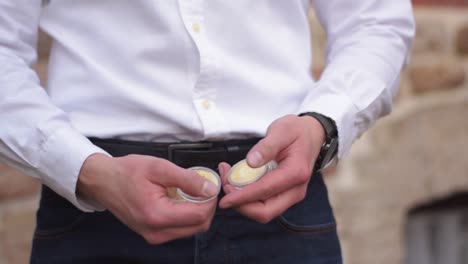 Hombre-De-Negocios-Con-Camisa-Blanca-Contando-Bitcoin-Dorado-Físico-En-Sus-Manos