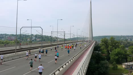 group of runners running on a bridge during the annual belgrade marathon in serbia