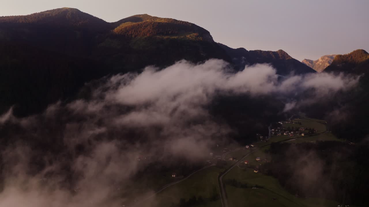 해가 뜨고 해가 지는 동안 안개가 인 알파인 계곡