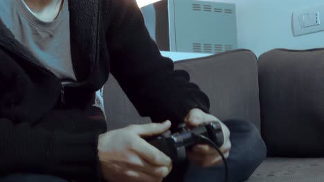 manos sosteniendo consola de videojuegos controlando joystick