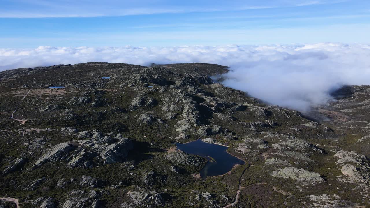 Vista aérea orbitando em torno de uma bela nuvem adentrando a montanha na Serra da Estrela, Portugal.