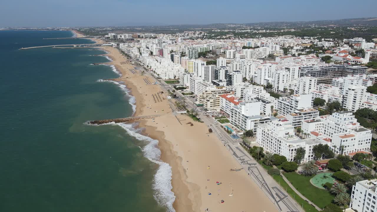 Aerial view of the coastline of the Quarteira city with beach and buildings