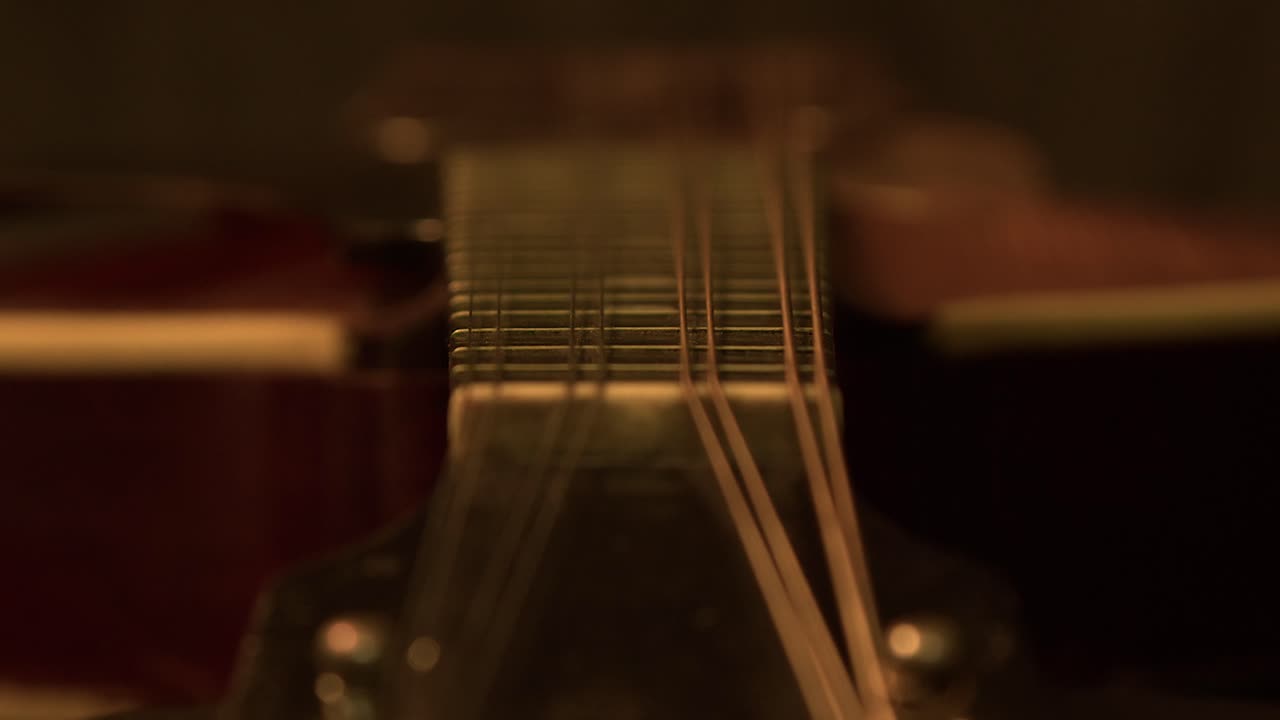 Messa a fuoco selettiva su un mandolino vintage dal ponte al capotasto della tastiera nell'oscurità.