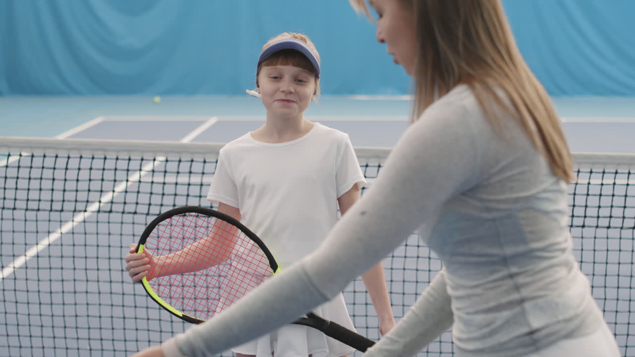 Girl On Tennis Training With Coach Indoors