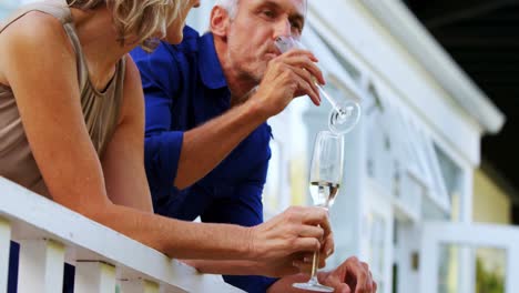 Couple-interacting-while-having-champange-in-balcony