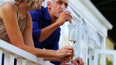 couple interacting while having champange in balcony