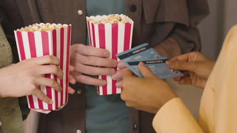 nahaufnahme einer platzanweiserin, die kinokarten eines paares im kino 1 kontrolliert und zerreißt