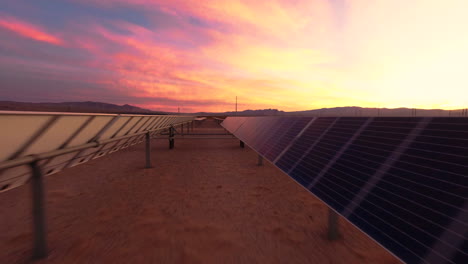 dron fpv volando en la granja solar del desierto durante la puesta o el amanecer