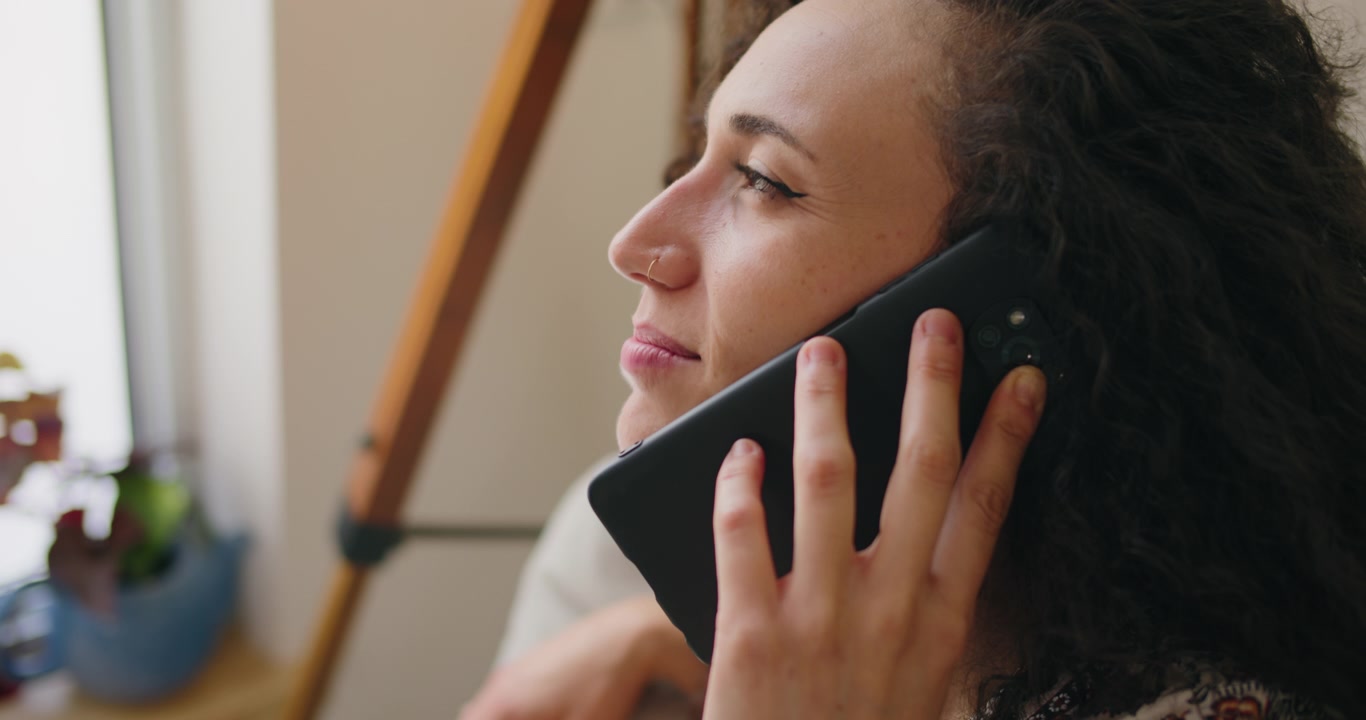 Young Woman Talking on Smartphone at Home