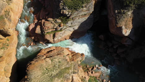 aerial revealing drone shot descending into a crevasse near the kel-suu lake in kyrgyzstan, downward angle